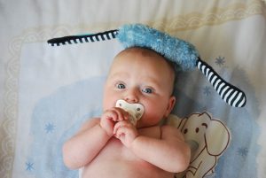 leżące niemowlę ze smoczkiem
